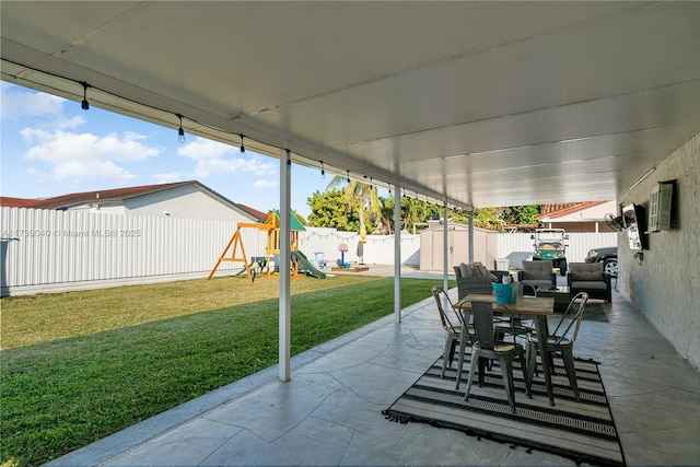 view of patio / terrace with a playground and a storage shed