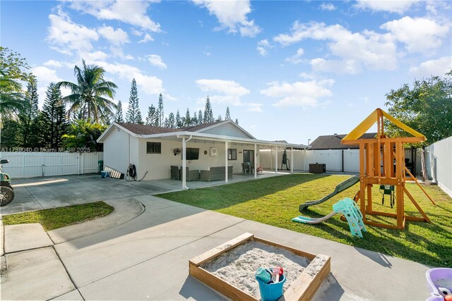 rear view of property featuring a yard, a playground, and a patio