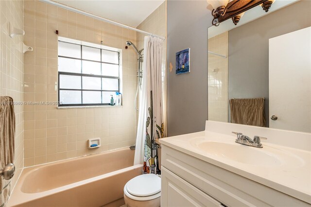 full bathroom with vanity, shower / bath combo with shower curtain, and toilet