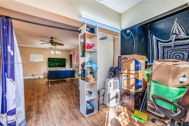 interior space with wood-type flooring, ceiling fan, and a textured ceiling