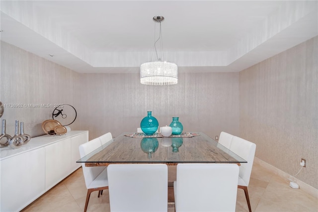 dining room featuring wallpapered walls, a tray ceiling, and light tile patterned flooring