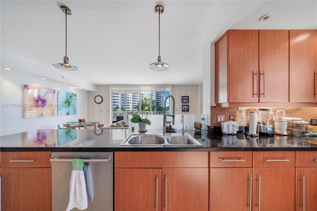 kitchen with a peninsula, a sink, dishwasher, dark countertops, and backsplash