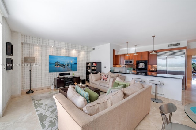 living area featuring light tile patterned floors and visible vents