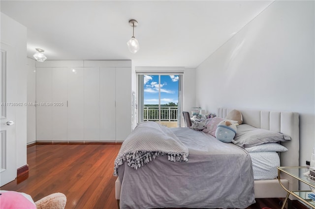 bedroom with access to exterior and wood finished floors