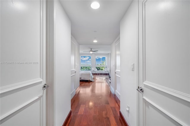 hall with dark wood-style floors and recessed lighting