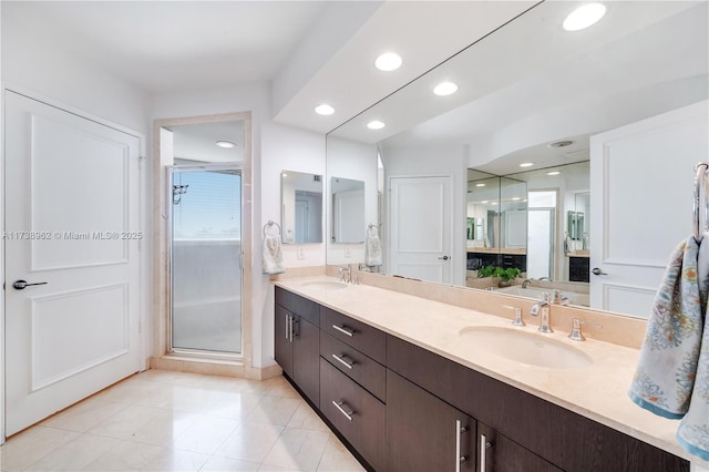 full bath with double vanity, recessed lighting, a shower stall, and a sink