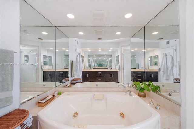 full bathroom with visible vents, recessed lighting, a jetted tub, and vanity