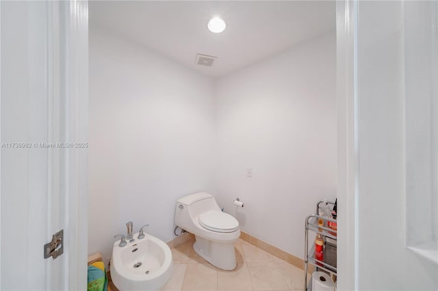 half bathroom featuring visible vents, baseboards, toilet, a bidet, and tile patterned floors