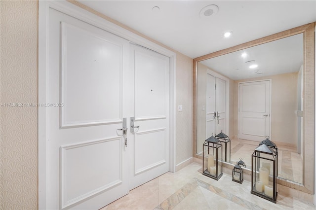 entrance foyer featuring recessed lighting, wallpapered walls, and baseboards