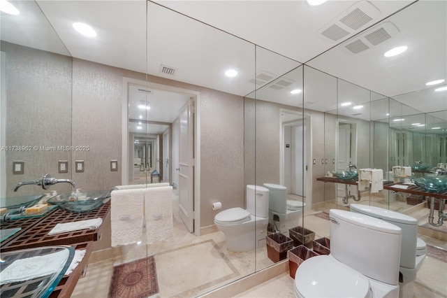 bathroom with toilet, recessed lighting, and visible vents