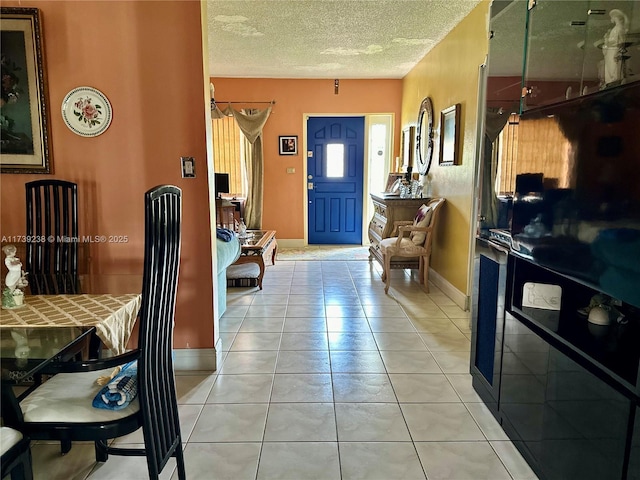 foyer entrance featuring light tile patterned floors and a textured ceiling