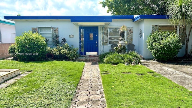 view of front of house with a front lawn and stucco siding