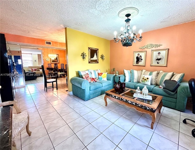 living room with light tile patterned floors, visible vents, a textured ceiling, and an inviting chandelier