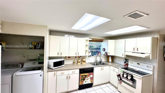 kitchen with washing machine and clothes dryer, sink, tasteful backsplash, white appliances, and white cabinets