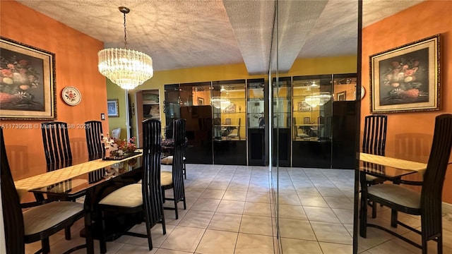 dining space featuring a textured ceiling, tile patterned floors, and an inviting chandelier