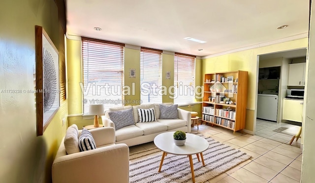 living room featuring tile patterned flooring, washer / clothes dryer, and crown molding