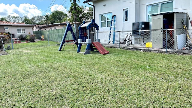 view of yard with cooling unit, a playground, and a fenced backyard