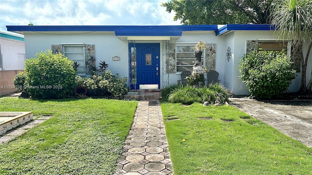 view of front facade with a front yard and stucco siding