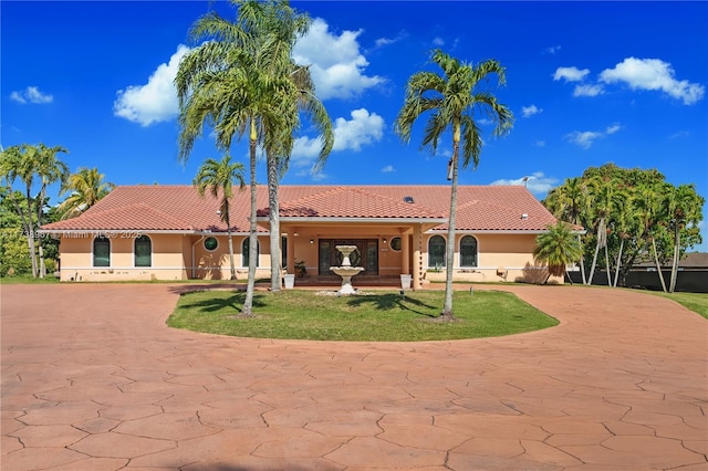 back of property featuring concrete driveway, a tile roof, and stucco siding