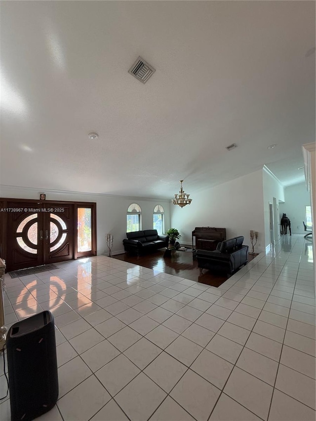 interior space with light tile patterned flooring, a notable chandelier, and french doors