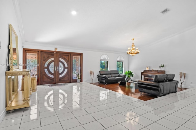 entrance foyer with french doors, crown molding, light tile patterned floors, a chandelier, and baseboards