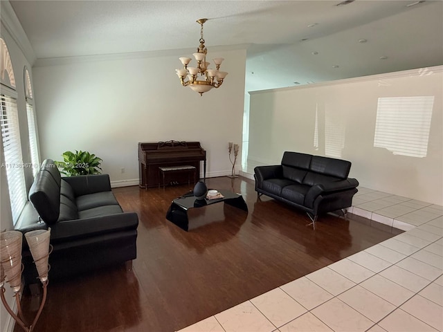 living area featuring a notable chandelier, crown molding, baseboards, and wood finished floors