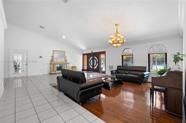 living area featuring a notable chandelier, crown molding, lofted ceiling, visible vents, and light wood-style floors