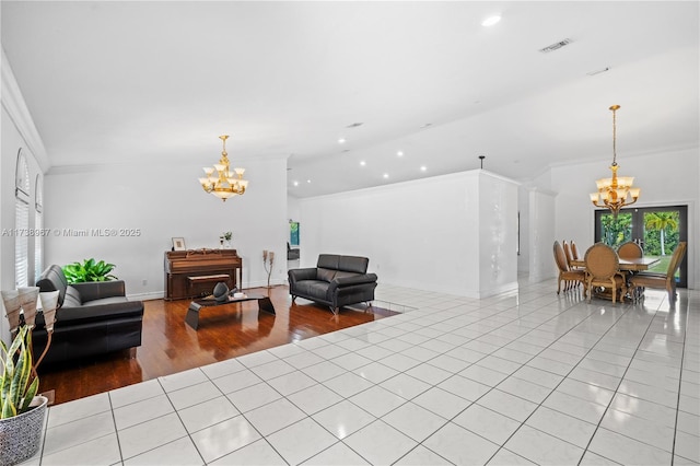 living area featuring visible vents, ornamental molding, a notable chandelier, and light tile patterned flooring