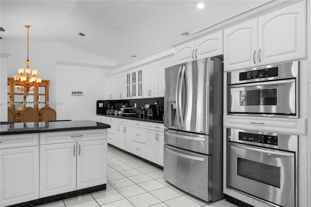 kitchen featuring lofted ceiling, white cabinets, stainless steel fridge with ice dispenser, dark stone countertops, and pendant lighting