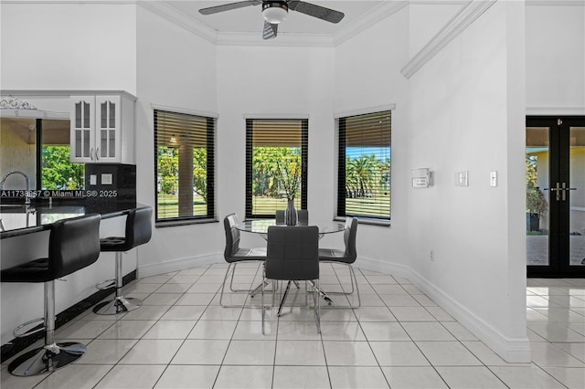 dining space featuring ornamental molding, french doors, light tile patterned floors, and a healthy amount of sunlight