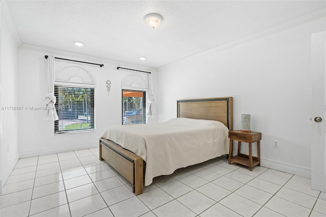 bedroom with crown molding, baseboards, and light tile patterned floors