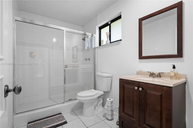 bathroom with a shower stall, vanity, toilet, and tile patterned floors