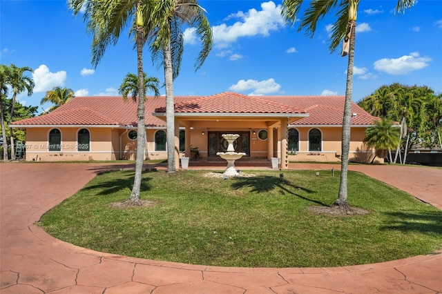 mediterranean / spanish house featuring a tile roof, driveway, and stucco siding