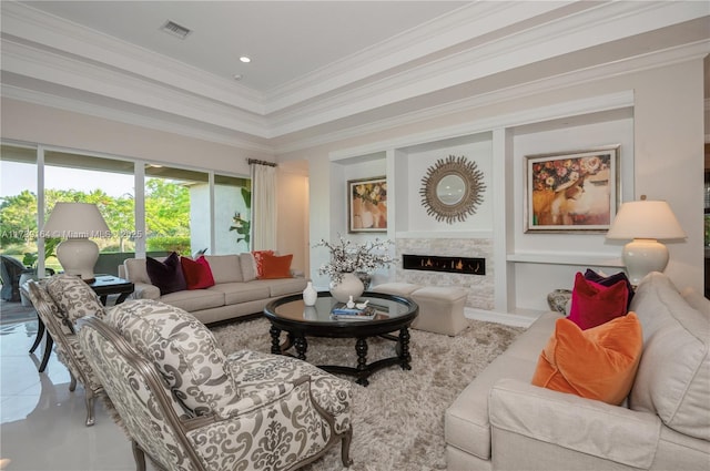 living room with a raised ceiling, crown molding, tile patterned flooring, and a fireplace