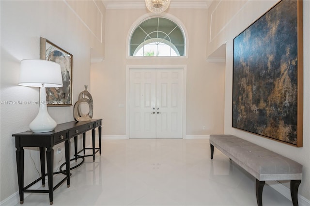 entrance foyer featuring crown molding and a chandelier