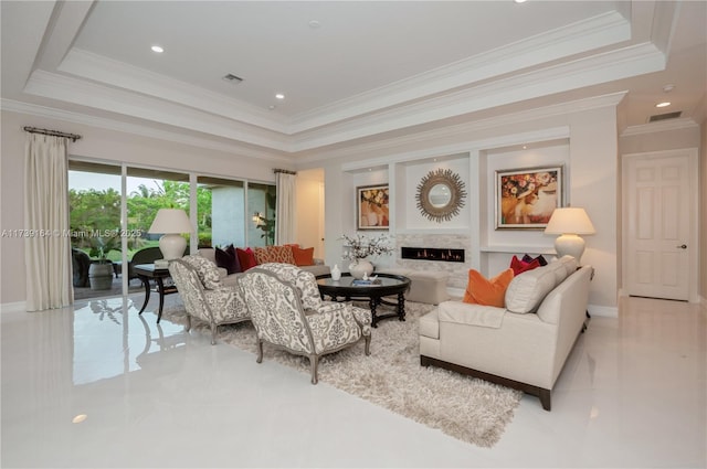 living room with a tray ceiling and a high end fireplace