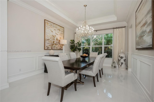 dining room featuring an inviting chandelier, crown molding, and a raised ceiling