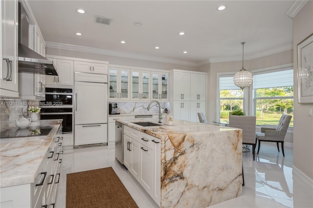 kitchen featuring sink, light stone counters, black appliances, an island with sink, and white cabinets