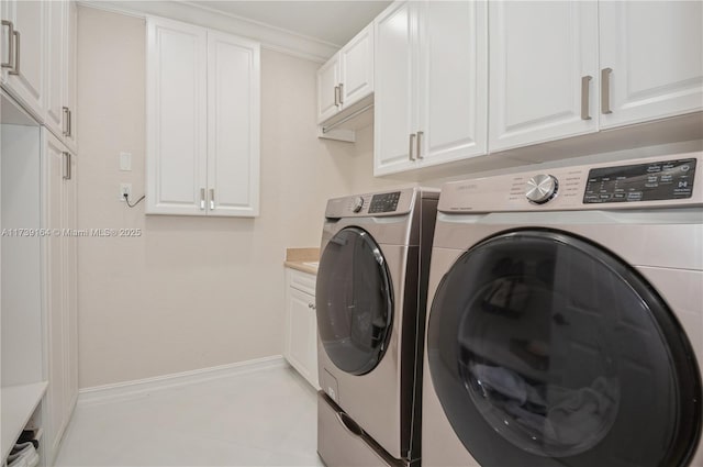 laundry room featuring cabinets, washer and dryer, and light tile patterned floors