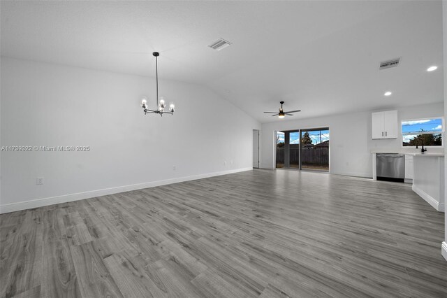 unfurnished living room featuring lofted ceiling, a healthy amount of sunlight, and light hardwood / wood-style flooring