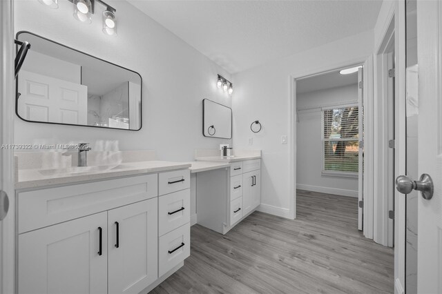 bathroom featuring vanity, hardwood / wood-style floors, and a textured ceiling