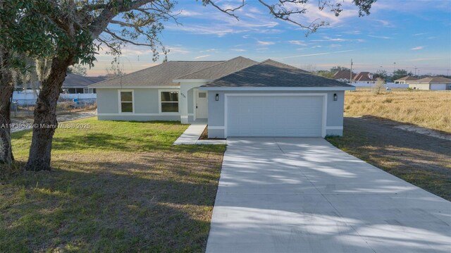 single story home featuring a yard and a garage