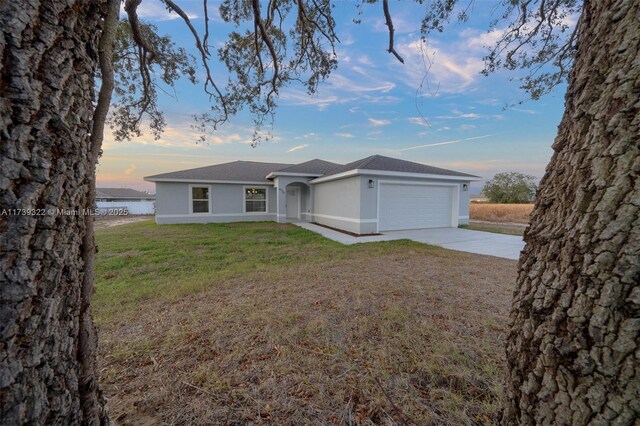 ranch-style house featuring a garage, a water view, and a yard