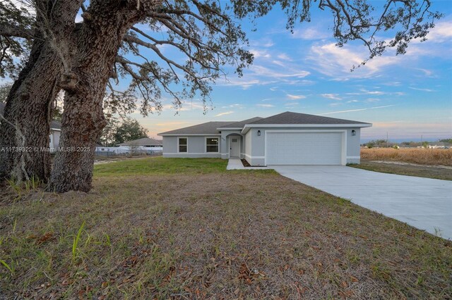 ranch-style home featuring a yard and a garage