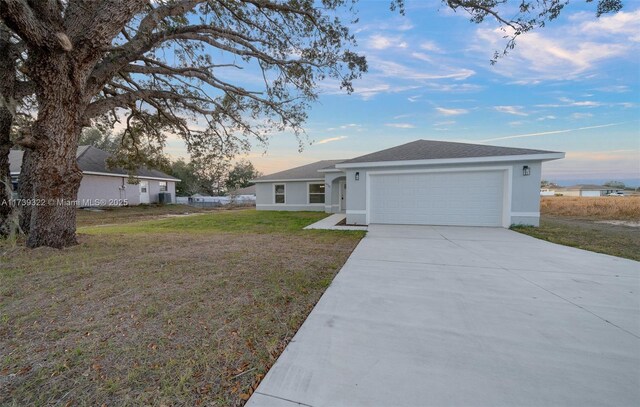 ranch-style house featuring a garage and a lawn