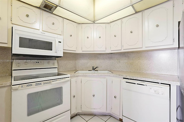 kitchen featuring white appliances, a sink, light countertops, and white cabinetry