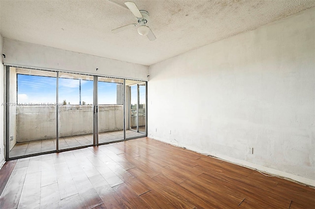 unfurnished bedroom featuring access to outside, wood finished floors, a textured ceiling, and ceiling fan