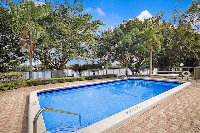 community pool featuring fence and a water view