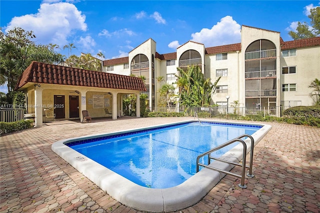 community pool featuring fence and a patio area