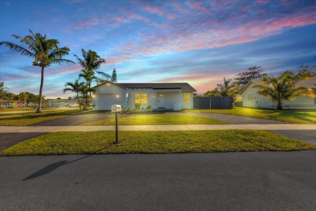 view of front of property with a garage and a lawn